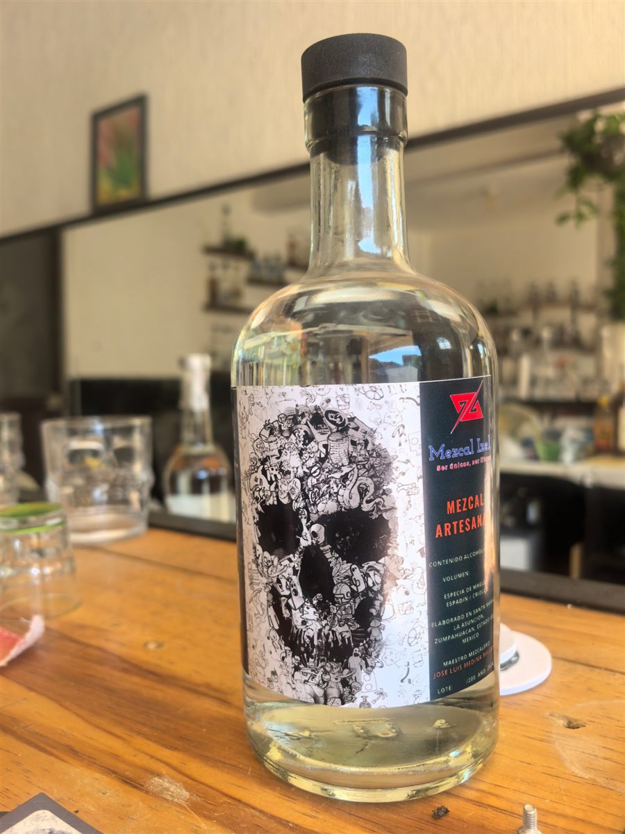 Botella de Mezcal Izel Espadín con su etiqueta de calavera ilustrada